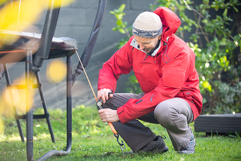 A person tying down their trampoline